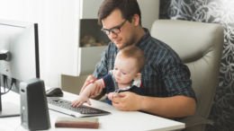 man working with baby on lap