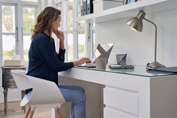A woman works remotely in her home office